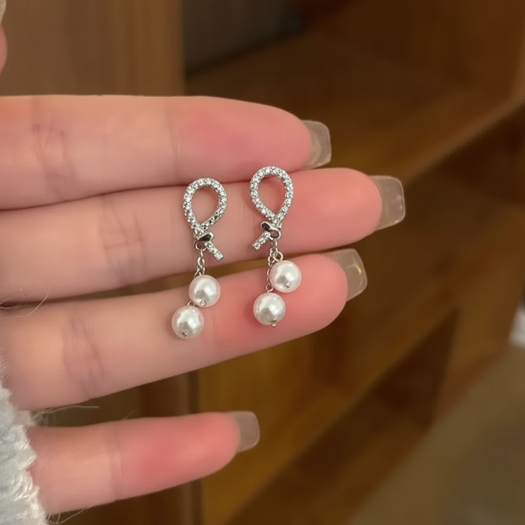 French full diamond pearl drop earrings held in hand