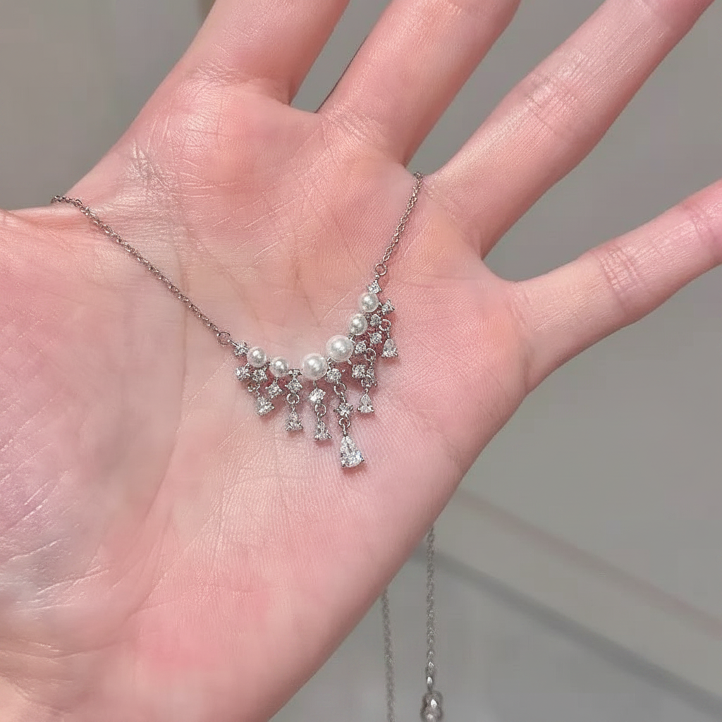 Sparkling teardrop tassel pearl necklace held in hand