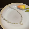 Camellia pearl necklace on white plate with tulip